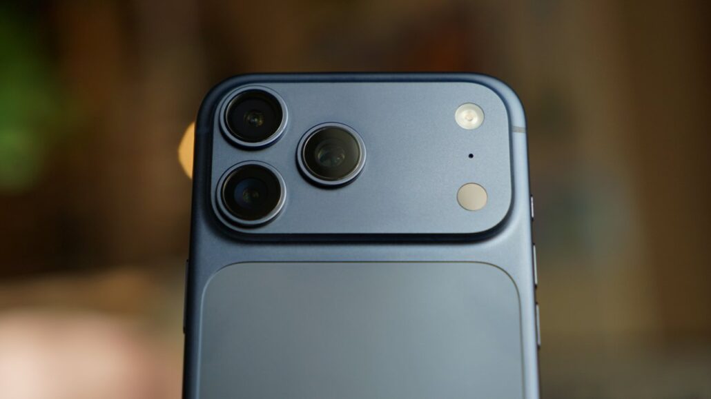 Close-up of a blue smartphone back showing a triple-camera module and flash.