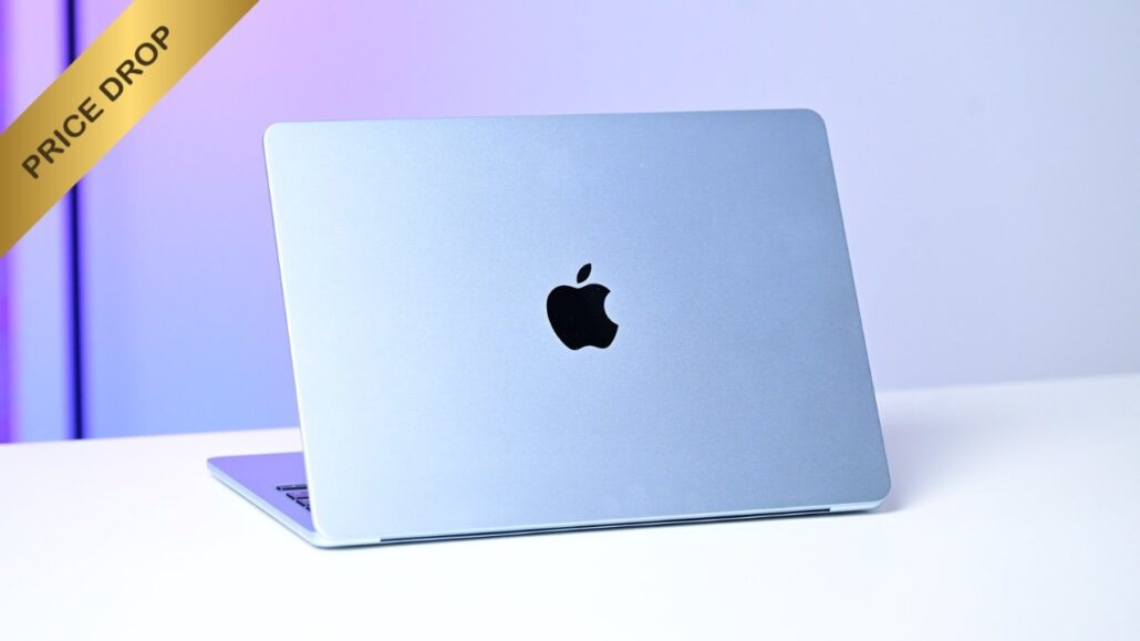 Silver MacBook closed on a white desk, Apple logo visible, with a gold PRICE DROP banner in the top-left corner.