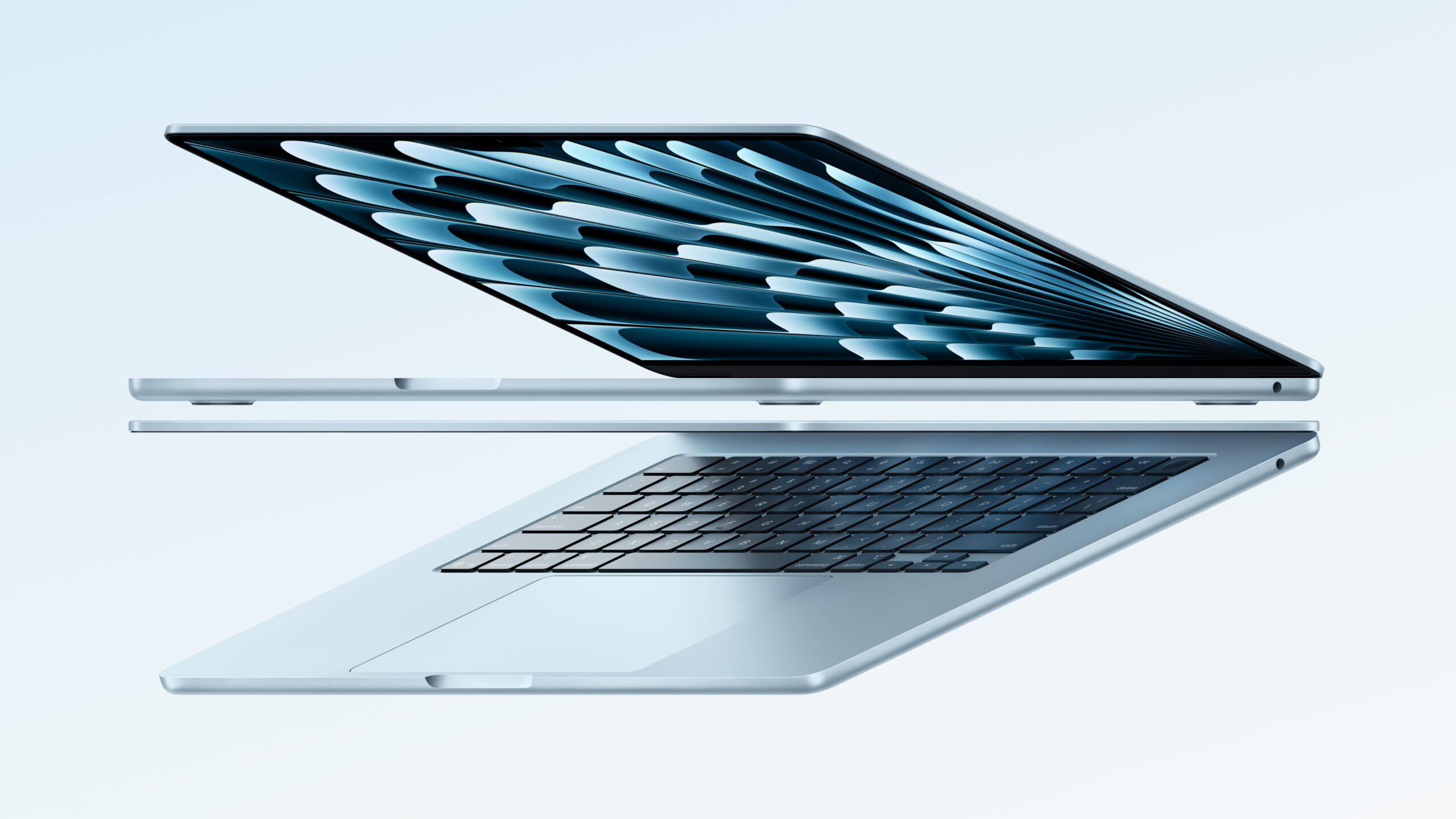 Slim silver laptop opened at a wide angle, screen displaying a blue abstract pattern against a pale blue background.