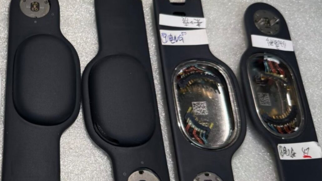 Black automotive door trim pieces laid flat, two with empty cavities and two showing metal inner housings with wiring and a QR code.