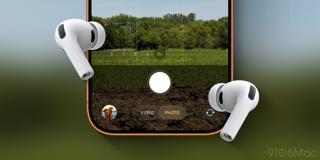 Close-up of a smartphone camera app with grid lines, 8x zoom indicator, circular shutter button, and two white wireless earbuds resting on the sides.
