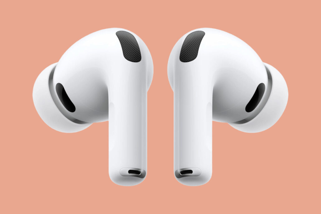 Pair of white true wireless earbuds against a peach background, facing upward to the sides