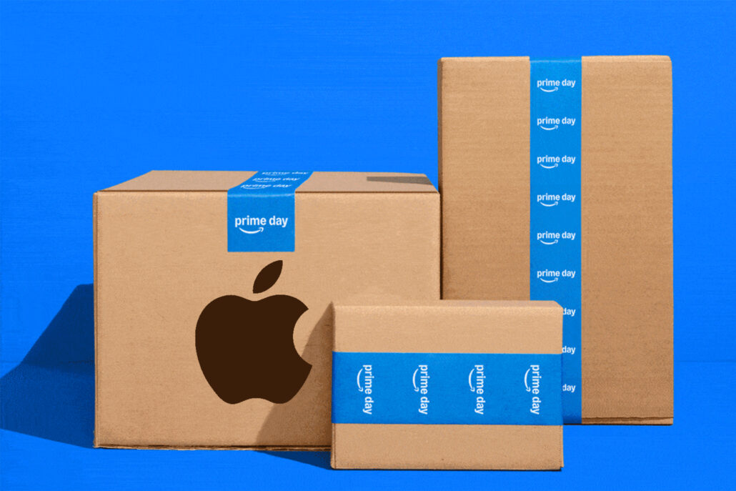 Amazon Prime Day Apple deals What to expect from the 4-day event - Dans Tutorials - Dans Tutorials A stack of brown cardboard boxes wrapped with blue Prime Day tape sits against a bright blue background, with part of a large dark Apple logo visible on the front box.