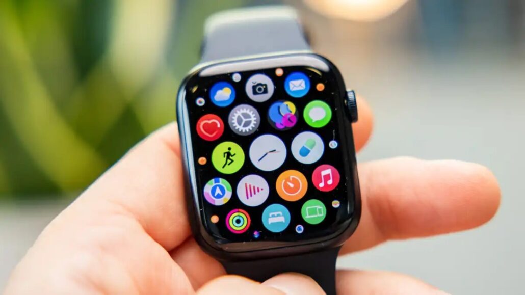 Close-up of a smartwatch on a hand displaying colorful app icons on its screen. But concise: 'Close-up of a smartwatch on a hand showing colorful app icons.'