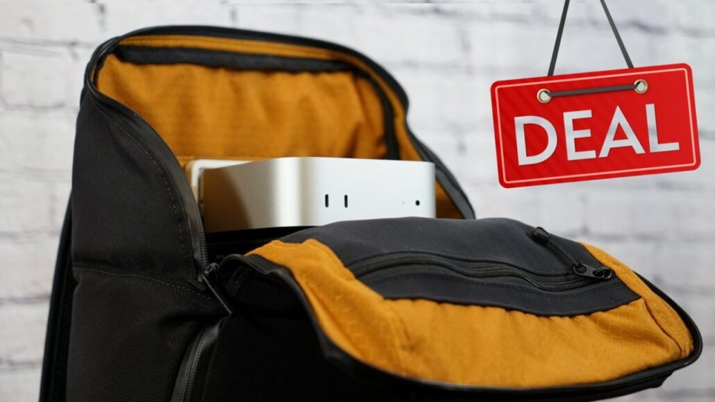 Apples M4 Mac mini is back in stock on sale for 9 but supply is limited - Dans Tutorials - Dans Tutorials Backpack with orange interior holding a silver gadget in the main pocket; a red 'DEAL' sign hangs nearby.