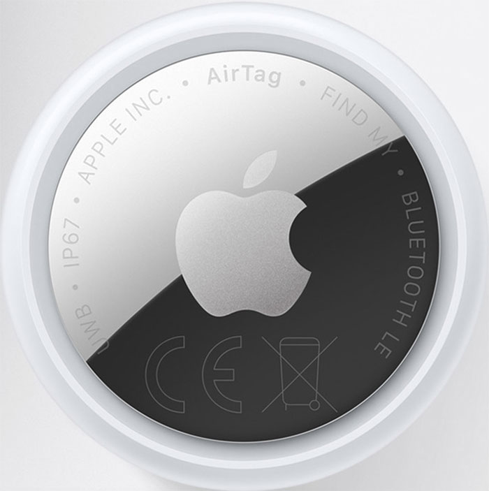 Close-up of an Apple AirTag: round white tracking device with the Apple logo visible on the front edge.
