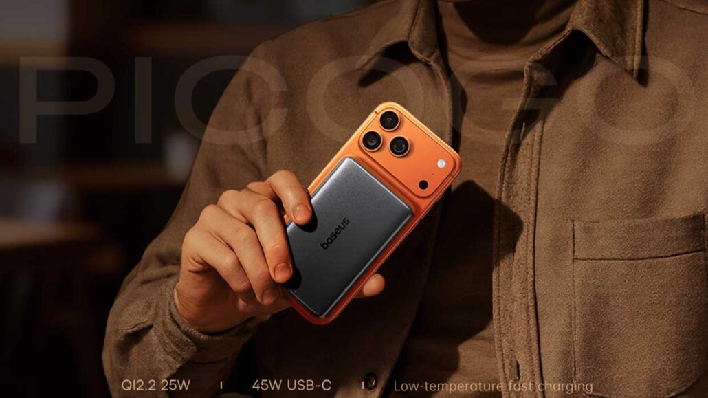 Hand holding an orange-back smartphone with three cameras, Baseus logo visible on the back.