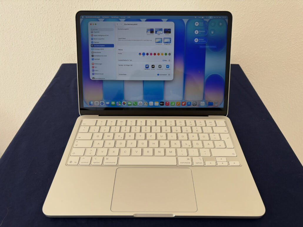 Watch this Franken-Neo come alive with official Apple parts - Dans Tutorials - Dans Tutorials White MacBook open on a dark blue surface, screen displaying macOS display settings in German, with colored theme options visible.